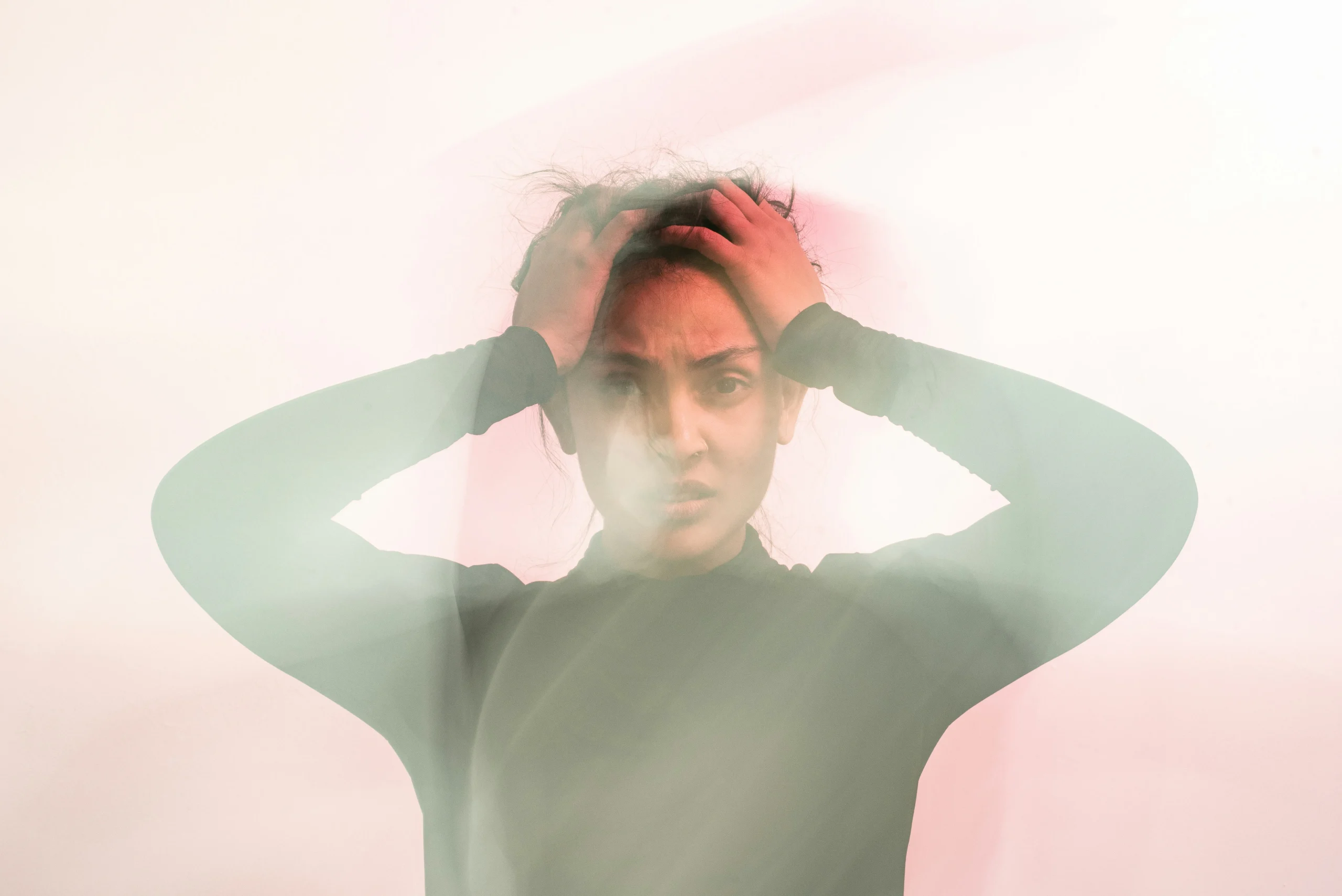 uday-mittal-bwKtz4YVtmA-unsplash Image of a woman holding her hands each side of her head in anguish.